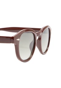 Okrągłe, burgundowe okulary przeciwsłoneczne z szarymi soczewkami, wykonane z plastiku. Posiadają grube oprawki i metaliczne akcenty w pobliżu zawiasów.
