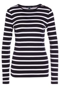 Svart- och vitt randig långärmad tröja med rund halsringning och tre dekorativa knappar på vänster axel. Tyget verkar slätt.