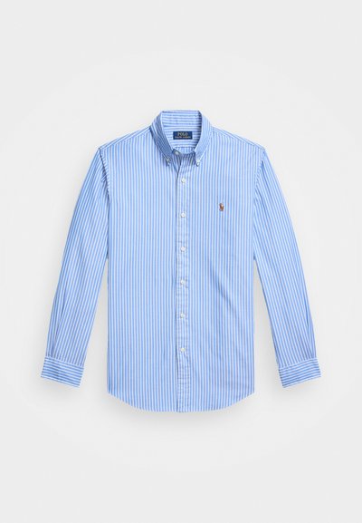 Sinine ja valge triibuline pikkade varrukatega nööbiga särk terava krae ja rinnal logo embleemiga. Puuvillane kangas sujuva tekstuuriga.