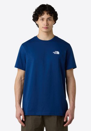 Navy blue cotton T-shirt with short sleeves, round neck, and a small white logo on the left chest. Smooth texture and relaxed fit.