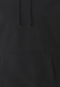 Black hoodie featuring a front pocket, drawstrings at the hood, and a soft, textured fabric. No visible logos or patterns.