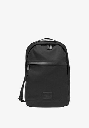 Sac à dos noir en tissu texturé. Comprend une poche zippée à l'avant, une fermeture à double zip et un petit patch logo. Bretelles ajustables.
