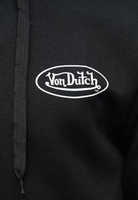 Zwarte hoodie met zwarte trekkoorden en een wit ovale logo met de tekst "Von Dutch" op de borst.