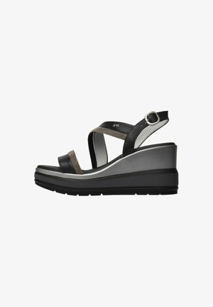Schwarze und silberne Keilsandalen verfügen über einen strukturierten Riemen und eine Knöchel-Schnalle, mit einer konturierten Plateausohle und einer Gummisohle für Stabilität.
