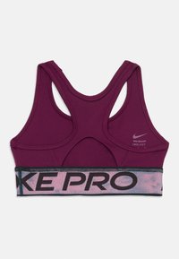 Fialová športová podprsenka Nike Pro s dizajnom na preteky, elastický pás s textom "NIKE PRO" a logom Dri-FIT na pravej zadnej strane.
