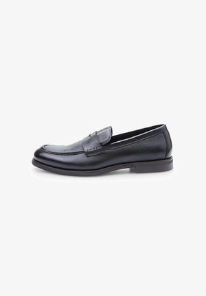 Zwarte leren instapschoenen met een gladde afwerking, ronde neus en een lage hak. Voorzien van een decoratieve strap en stikinstructie aan de voorkant.