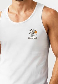 White tank top with a round neck, featuring a palm tree and sun graphic in brown and orange, with "Neverless" text below the design.
