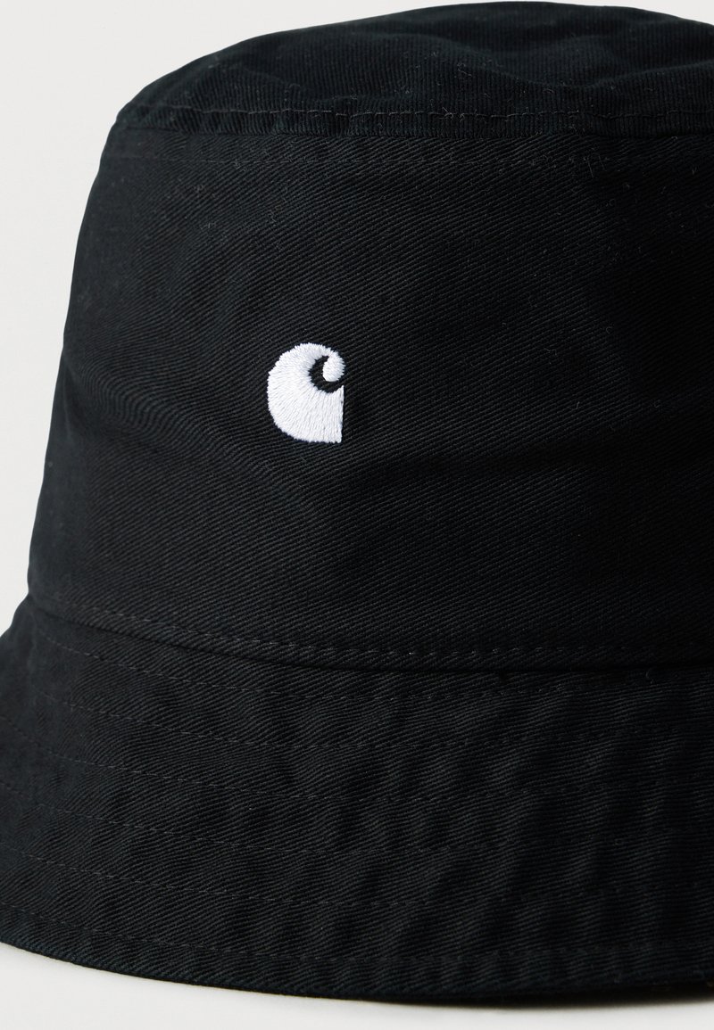 Chapeau seau noir en tissu durable avec une finition texturée. Présente un logo brodé blanc à l'avant.