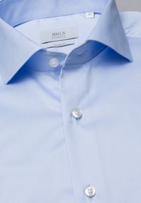 Camicia azzurro chiaro, slim fit, realizzata in tessuto liscio, con colletto classico e bottoni bianchi. Etichetta con la scritta "1863 Eterna."