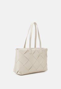 Beige vävd bärväska tillverkad av syntetmaterial, med två förlängda handtag och en strukturerad form med detaljer i diamantmönster.