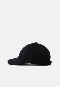 Svart kordfløyels baseballcap med buet skygge, teksturert stoff, og et justerbart spenne bak. Syv ventilasjons hull synlige.