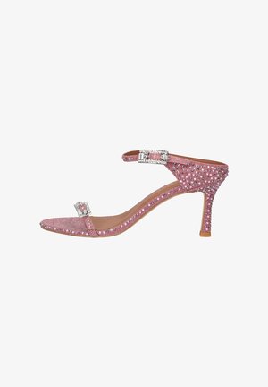 Roze sandaal met hoge hak, enkelbandje en teenbandje, versierd met fonkelende strasstenen en zilveren gespsieraden.