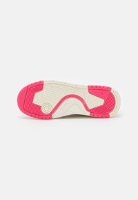Sole of a sneaker featuring a textured white base with bright pink accents and triangular tread patterns for grip. Includes brand logo.