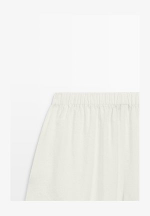 Weißer Rock mit elastischem Bund, weich strukturierter Stoff, plissiertes Design, vor einem schlichten weißen Hintergrund präsentiert.