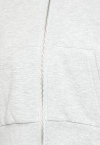 Ljusgrå zip-up hoodie gjord av mjukt bomullsblandat tyg. Har en framzip och två rymliga framfickor.