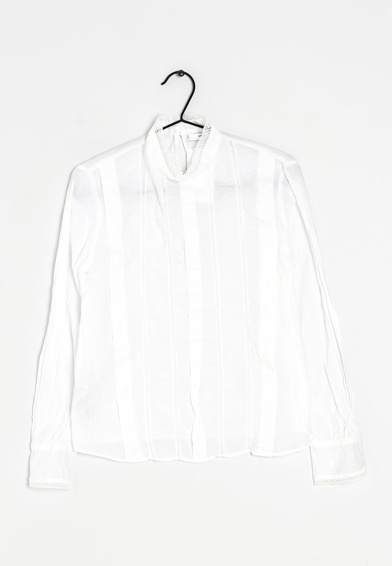 Valkoinen pitkähiha-paita, jossa on pystyraidat, pitsireunus kauluksessa ja hihoissa, teksturoitu kangas. Roikkuu mustassa koukussa.