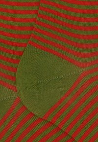 Calzini a righe con strisce alternate rosse e verdi, dotati di un motivo a maglia testurizzato e di un'area del tallone rinforzata.