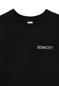 Maglietta nera con logo bianco "SEX AND THE CITY" stampato sulla parte sinistra del petto, con scollatura rotonda.