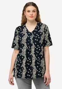 Námořnický top s krátkým rukávem a véčkovým výstřihem, s bílým květinovým vzorem a skládáním v přední části pro přidanou texturu.