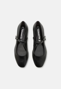 Zapatos planos Mary Jane de cuero negro con punta redondeada y una delgada correa con hebilla. Textura suave y diseño sencillo. Talla 36.