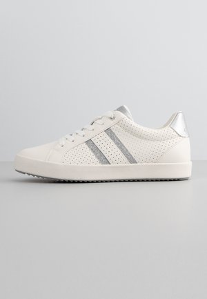 Baskets blanches avec des accents argentés. Présentent un design perforé, un devant lacé et une semelle texturée grise. Un onglet de talon métallique ajoute du détail.