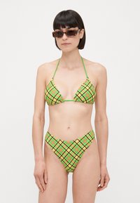 Bikini set v zelenej a žltej kocke, obsahujúci trojuholníkový top s tenkými ramienkami a vysoko vykrojené spodné diely, vyrobený z hladkej, ľahkej tkaniny.