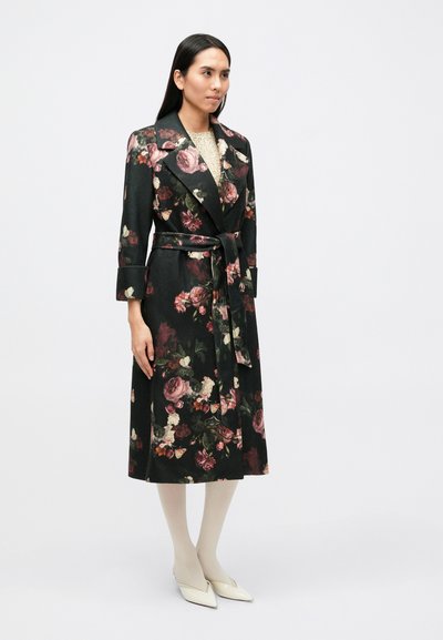 Mustal taustal lillemustriga mantel, pikad varrukad ja vööga. Omab kraed ning ulatub põlveni. Tekstuuriga kangas.