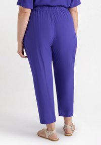 Paarse lichtgewicht broek met een relaxed fit, elastische tailleband en cropped lengte. Zachte textuur en eenvoudig ontwerp.