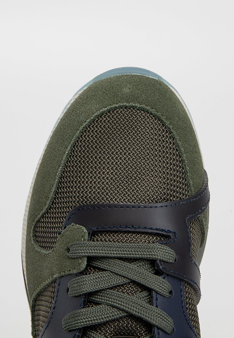 Zielone zamszowe i siateczkowe sneakersy z ciemnoniebieskim skórzanym akcentem, teksturowana cholewka i okrągły czubek. Zawierają sznurówki i przezroczystą podeszwę.
