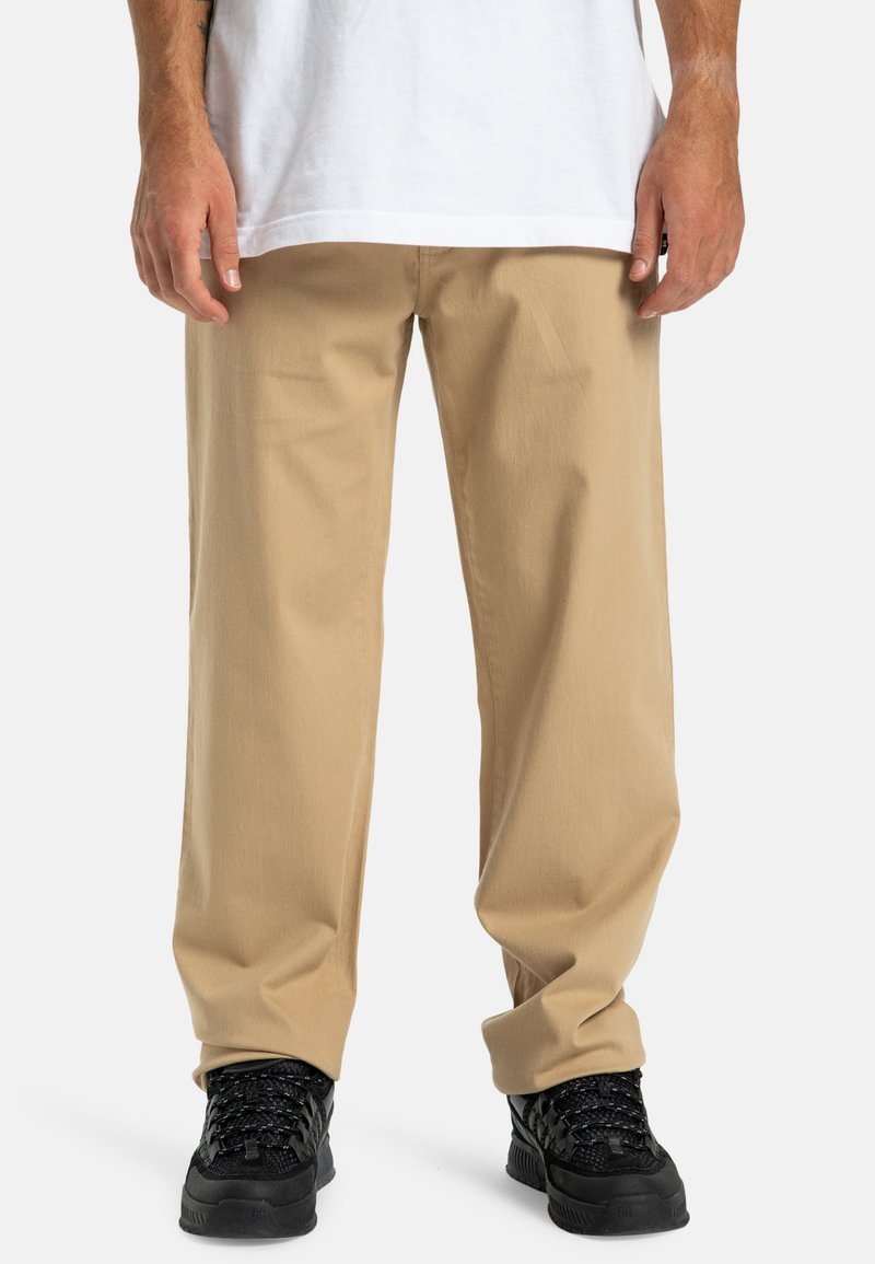 Beige rechte broek gemaakt van katoen, met een eenvoudig ontwerp en een gladde textuur. Gemaakt om te dragen met zwarte sneakers met textuur.