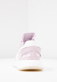 Rosa sneaker i mocka och mesh med vit sula, med utskurna detaljer och en vadderad hälflik för komfort.