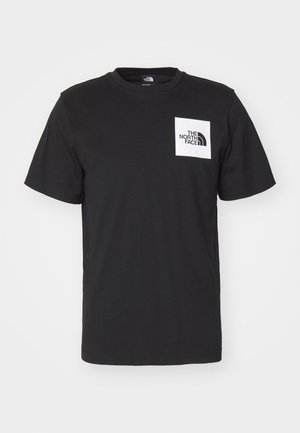 Juodas medvilnės marškinėliai su trumpomis rankovėmis, apvaliu kaklu ir baltu kvadratinio formato logotipu ant krūtinės, kuriame yra tekstas "The North Face" ir kreivas dizainas.
