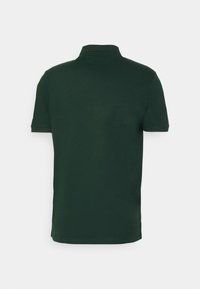 Tmavě zelené polo tričko s klasickým límcem, krátkými rukávy a hladkou texturou. Žádné viditelné logo ani vzory.
