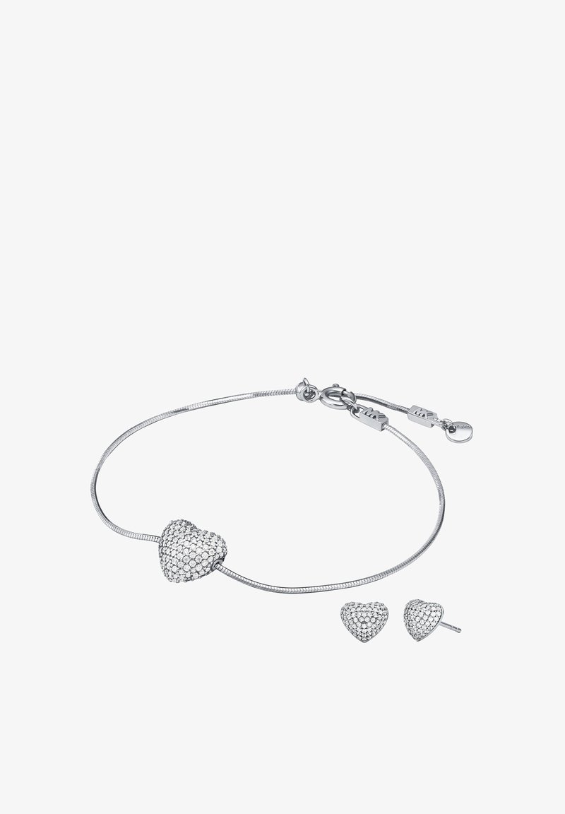 Hopeaketju hopeasta, jossa sydämen muotoinen riipus, jota koristavat kimaltelevat kivet, ja siihen sopivat sydämen muotoiset nappikorvakorut.