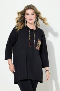 T-shirt nera oversize con maniche a tre quarti, caratterizzata da una tasca con stampa leopardata e cordini. Tessuto morbido e vestibilità rilassata.
