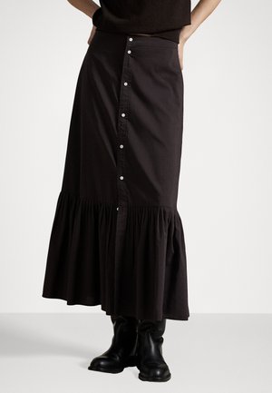 Black, knee-length button-up skirt made of cotton, featuring a tiered hem and gathered fabric. Paired with black ankle boots.