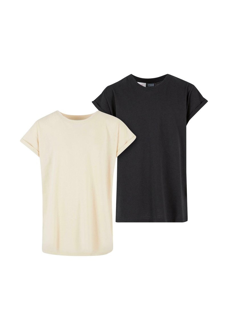 Två kortärmade t-shirts: en krämfärgad och en svart, tillverkade av mjuk bomull, med en enkel, avslappnad passform och uppvikta ärmar.