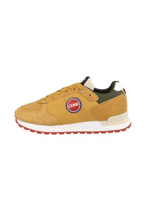 Lage gele en olijfgroene sneaker met suède details, rood-wit Colmar-logo, witte tussenzool en rode rubberen buitenzool.