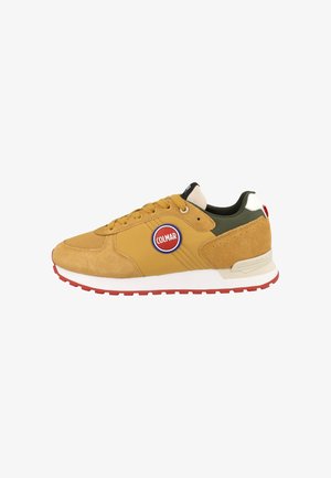 Zapatilla baja en amarillo y oliva con detalles de ante, logo Colmar rojo y blanco, entresuela blanca y suela exterior de goma roja.