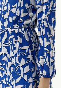 Blau-weiß gemustertes Kleid mit abstrakten Formen, weichem Stoff, langen Ärmeln und elastischen Ärmelbündchen, tailliert.