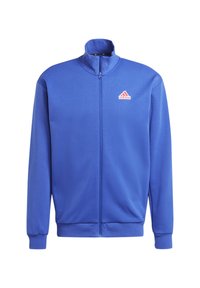 Blauwe zip-up jas van gladde stof. Heeft een hoge kraag, ribbelmanchetten en een rood Adidas-logo aan de bovenlinkerzijde.