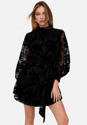 Schwarzes, floral gemustertes Kleid aus transparentem Stoff mit Puffärmeln, gerafftem Ausschnitt und einem Bindegürtel in der Taille. Strukturierte Blumenakzente.