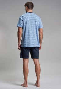 Camisa de manga corta a rayas azul claro con pantalones cortos azul marino, hecha de un tejido suave, que presenta patrones horizontales y verticales.