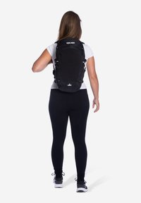 Zwarte rugzak met verstelbare banden, gestructureerde vorm, gladde stof, voorvak met rits en een logo aan de onderkant. Draag bij je rug.