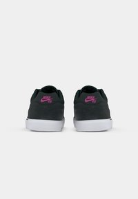 Nike SB sportbačiai tamsiai pilkos zomšos, su baltais guminiais padais ir rožiniu logotipu ant kulno. Suapvalinta forma, minimalistinis dizainas.