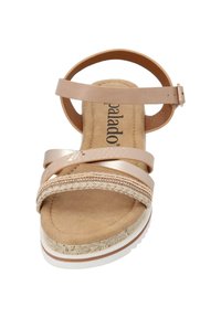 Sandale beige avec des brides synthétiques entrecroisées, une semelle intérieure en daim doux et une semelle blanche texturée. Comprend des accents décoratifs en tresses.