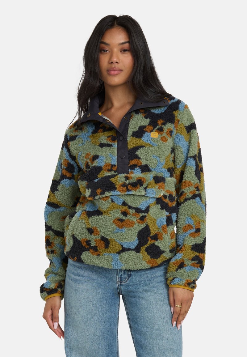 Flauschiger Pullover mit einem mehrfarbigen Blumenmuster in Grün, Blau und Orange, der einen geknöpften schwarzen Kragen und eine Taschenfront aufweist.