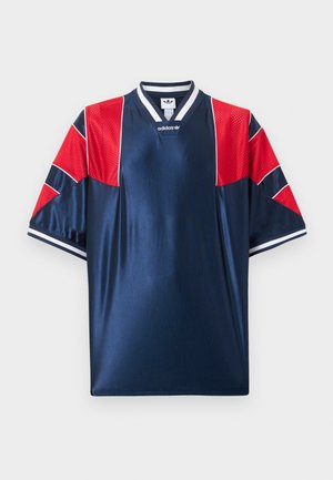 Temno modra športna majica Adidas z rdečimi mrežastimi paneli na ramenih in rokavih, belo črtastim ovratnikom in manšetami ter logotipom na prsih.