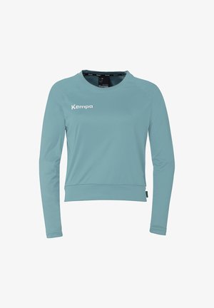 Lichtblauw longsleeve shirt van soepel stof, met een ronde halslijn en een wit "Kempa" logo op de borst.