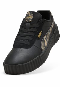 Schwarze Sneakers mit einem strukturierten Lederobermaterial, das ein beiges Schlangenledermuster an der Seite aufweist, dicker, geriffelter Sohle und schwarzen Schnürsenkeln.